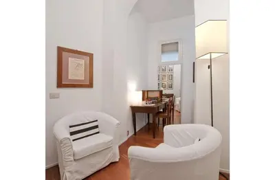 a living room with two white chairs and a table at B&B Colori di Roma in Rome