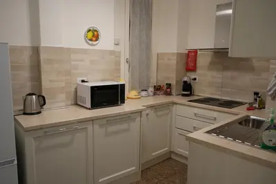 a kitchen with white cabinets and a microwave at Casa Giovanna in Rome