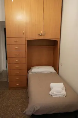 a bed with a wooden cabinet and towels on it at Casa Giovanna in Rome