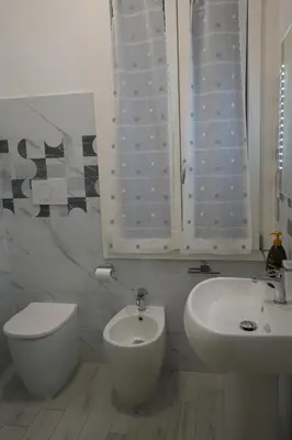 a white bathroom with a toilet and a sink at Casa Giovanna in Rome