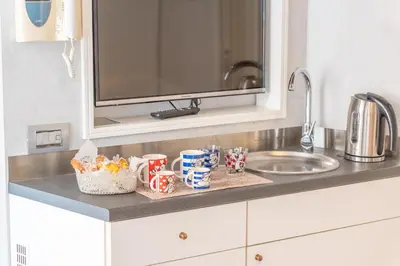 a kitchen counter with cups and a sink at Secret Studio Retreat in the Heart of the Ghetto by Houseeds in Rome