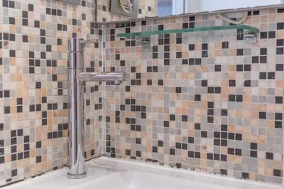 a bathroom with a shower with a tile wall at Secret Studio Retreat in the Heart of the Ghetto by Houseeds in Rome
