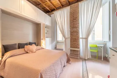 a bedroom with a large bed with a large window at Secret Studio Retreat in the Heart of the Ghetto by Houseeds in Rome