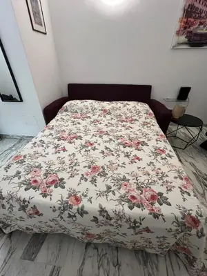 a bed with a floral bedspread on it in a bedroom at Casa Vale in Rome
