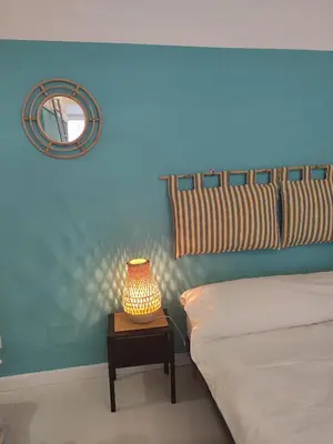 a bedroom with a bed and a table with a lamp at Colosseum Studio Flat blue in Rome