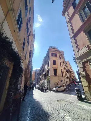 a cobblestone street in a city with buildings and a car at Colosseum Studio Flat blue in Rome