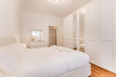 a white bedroom with a large white bed at Zampieri Loft in Rome