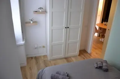 a bedroom with white cabinets and a bed with slippers at Il Rifugio dell Inventore in Rome