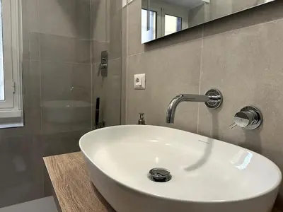 a white sink in a bathroom with a mirror at Il Rifugio dell Inventore in Rome