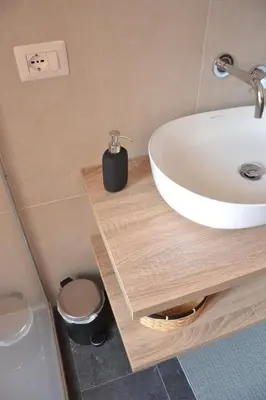 a bathroom with a white sink on a wooden counter at Il Rifugio dell Inventore in Rome