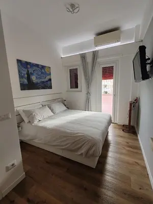 a bedroom with a large white bed and a television at Domus MT481 in Rome