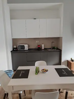 a kitchen with a white table and white cabinets at Domus MT481 in Rome