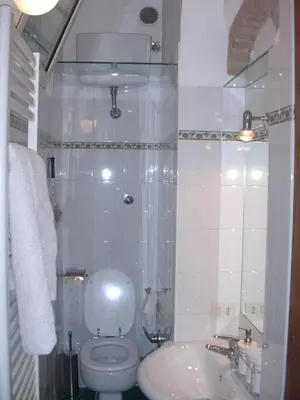 a white bathroom with a toilet and a sink at Vacanze al Colosseo Polveriera in Rome