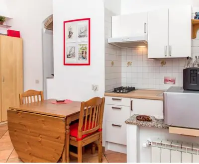 a kitchen with a wooden table and chairs and a counter at Vacanze al Colosseo Polveriera in Rome