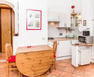 a kitchen with a wooden table and chairs in it at Vacanze al Colosseo Polveriera in Rome