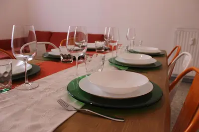 a table with plates and wine glasses on it at Tiberim, Centro Storico in Rome