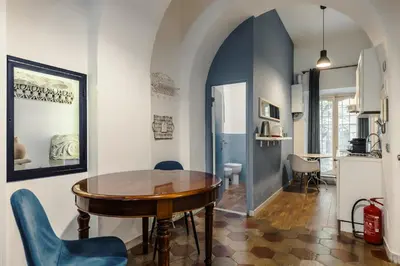 a dining room with a wooden table and blue chairs at Vatican Home in Rome