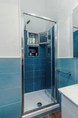 a bathroom with a shower with blue tiles at Vatican Home in Rome