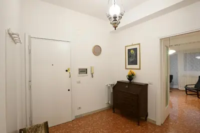 a white room with a door and a clock on the wall at Vatican Firefly House in Rome