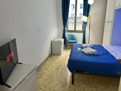a bedroom with a blue bed and a tv at appartamento elegante Roma - Vicino alla metro in Rome