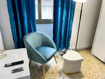 a living room with a blue chair and a table at appartamento elegante Roma - Vicino alla metro in Rome