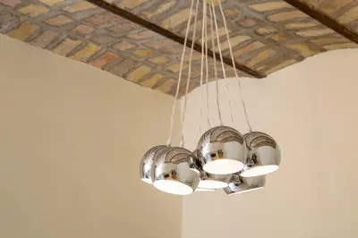 a cluster of lights hanging from a ceiling at La Casina Vaticana in Rome