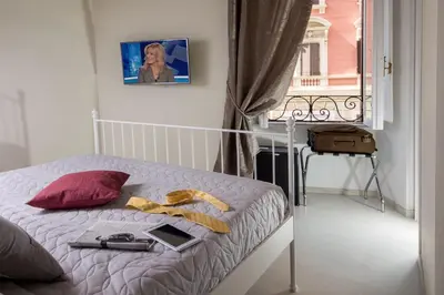 a bedroom with a bed with a laptop and a window at La Casina Vaticana in Rome