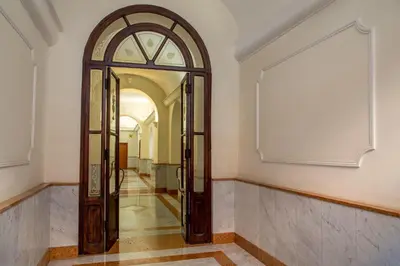 a hallway with a large mirror and an arch doorway at La Casina Vaticana in Rome