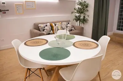 a white dining room table with white chairs and a couch at Pon Pon Sweet Home in Rome