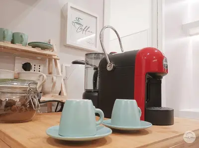 a red coffee maker and two cups on a table at Pon Pon Sweet Home in Rome