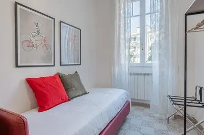 a bedroom with a bed with red pillows on it at La Casetta di San Giovanni in Rome