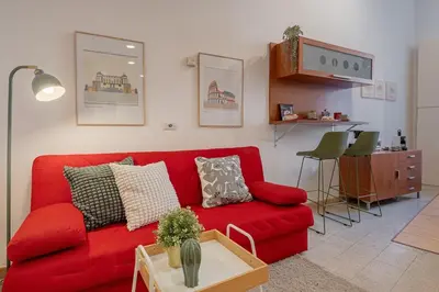 a living room with a red couch and a table at La Casetta di San Giovanni in Rome