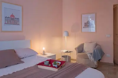 a bedroom with a bed and a chair with a tray on it at La Casetta di San Giovanni in Rome