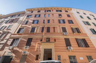 a large orange building with windows on a street at La Casetta di San Giovanni in Rome