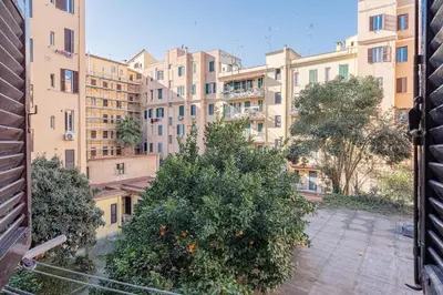an apartment with an orange tree in front of buildings at La Casetta di San Giovanni in Rome
