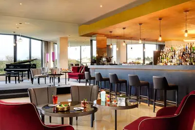 a restaurant with a bar and a grand piano at A.Roma Lifestyle Hotel in Rome