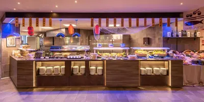a restaurant with a counter with food on it at A.Roma Lifestyle Hotel in Rome