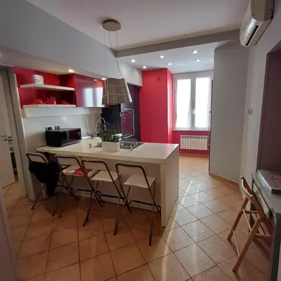 a kitchen with red cabinets and a table and chairs at Apt Osci in Rome
