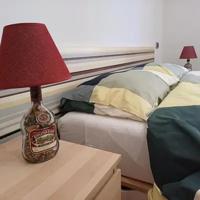 a bottle of honey sitting on a table next to a bed at Apt Osci in Rome