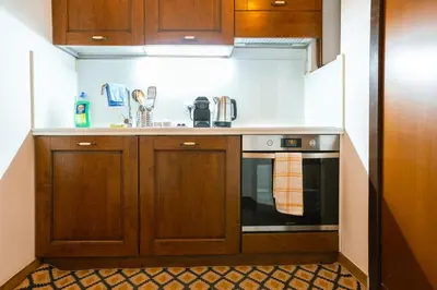 a kitchen with wooden cabinets and a stove at Stylish Studio in Sallustiano in Rome
