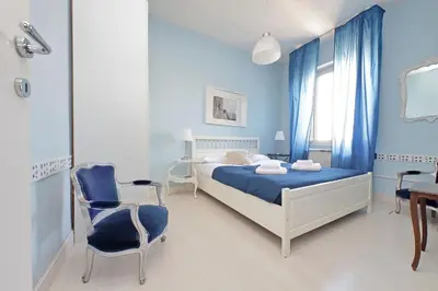 a blue bedroom with a bed and a chair at 6 People Apartment at Vatican in Rome