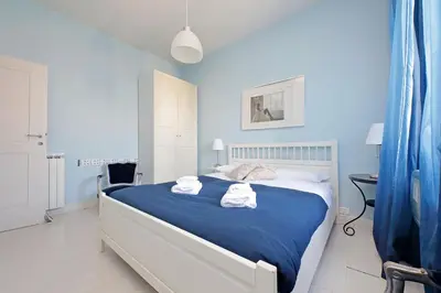 a blue bedroom with a bed with towels on it at 6 People Apartment at Vatican in Rome