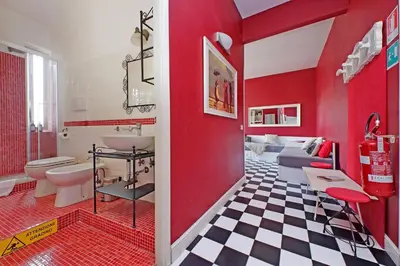 a bathroom with red walls and a checkered floor at 6 People Apartment at Vatican in Rome
