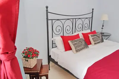 a bedroom with a bed with red and white pillows at 6 People Apartment at Vatican in Rome