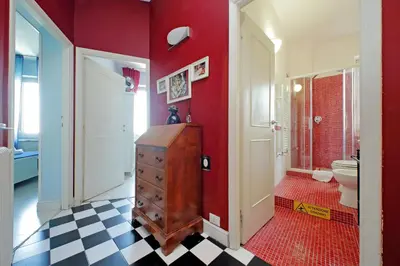 a bathroom with a red wall with a sink and a toilet at 6 People Apartment at Vatican in Rome
