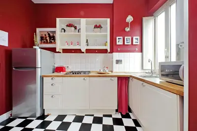 a kitchen with red walls and a black and white checkered floor at 6 People Apartment at Vatican in Rome