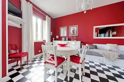 a red bedroom with a white table and chairs at 6 People Apartment at Vatican in Rome