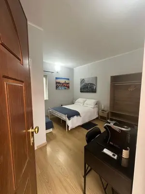 a bedroom with a bed and a desk with a table sidx sidx sidx at Alloggio Fiorella in Rome