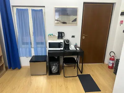 a room with a table with a microwave and a door at Alloggio Fiorella in Rome