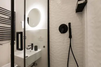 a bathroom with a shower with a mirror and a sink at Be Max Guest House in Rome